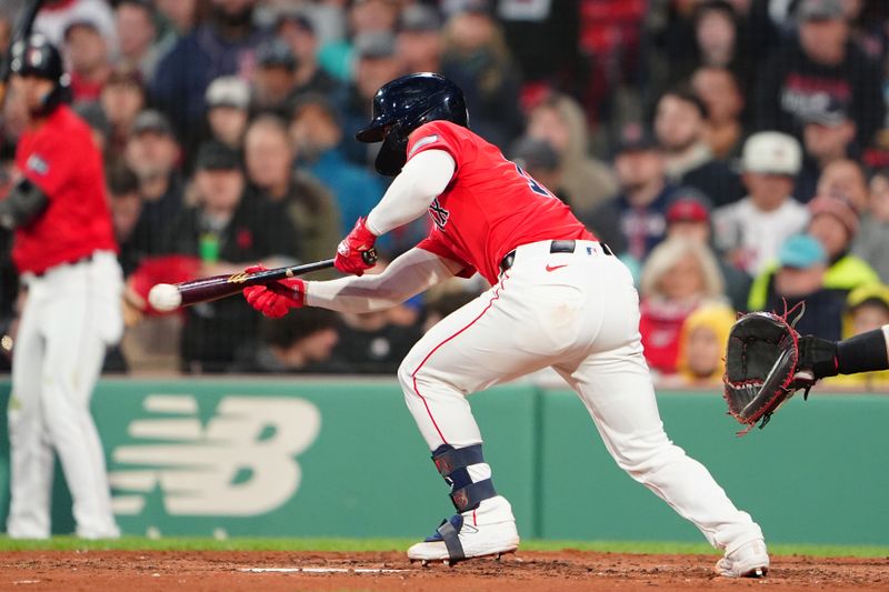 May 10, 2024; Boston, Massachusetts, USA; Boston Red Sox catcher Connor Wong (12) bunts for a base hit against the Washington Nationals during the fourth inning at Fenway Park. Mandatory Credit: Gregory Fisher-USA TODAY Sports