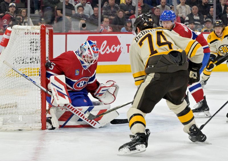 Mar 14, 2024; Montreal, Quebec, CAN; Montreal Canadiens goalie Sam Montembeault (35) makes a save in front of Boston Bruins forward Jake DeBrusk (74) during the first period at the Bell Centre. Mandatory Credit: Eric Bolte-USA TODAY Sports