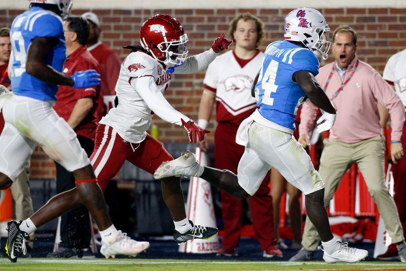 Oct 7, 2023; Oxford, Mississippi, USA; Mississippi Rebels running back Ulysses Bentley IV (24) runs the ball as Arkansas Razorbacks defensive back Lorando Johnson (1) shoves him out of bounds during the second half  at Vaught-Hemingway Stadium. Mandatory Credit: Petre Thomas-USA TODAY Sports