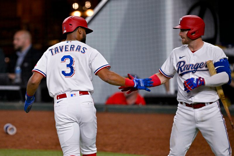 May 16, 2023; Arlington, Texas, USA; Texas Rangers center fielder Leody Taveras (3) and right fielder Robbie Grossman (4) celebrate after Taveras scores against the Atlanta Braves during the seventh inning at Globe Life Field. Mandatory Credit: Jerome Miron-USA TODAY Sports