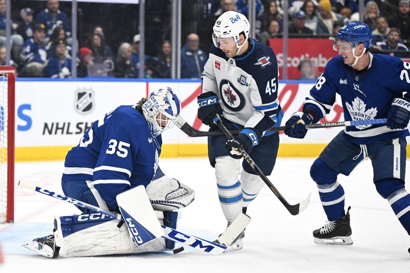 Jan 1, 2026; Toronto, Ontario, CAN;   Toronto Maple Leafs goalie Dennis Hildeby (35) makes a save as Winnipeg Jets forward Cole Koepke (45) looks for the rebound in the second period at Scotiabank Arena. Mandatory Credit: Dan Hamilton-Imagn Images