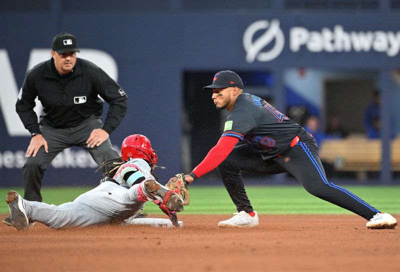 Aug 21, 2024; Toronto, Ontario, CAN;  Toronto Blue Jays second baseman Leo Jimenez (49) tags out Cincinnati Reds shortstop Elly De La Cruz (44) who was trying to stretch a single into a double in the fourth inning at Rogers Centre. Mandatory Credit: Dan Hamilton-USA TODAY Sports