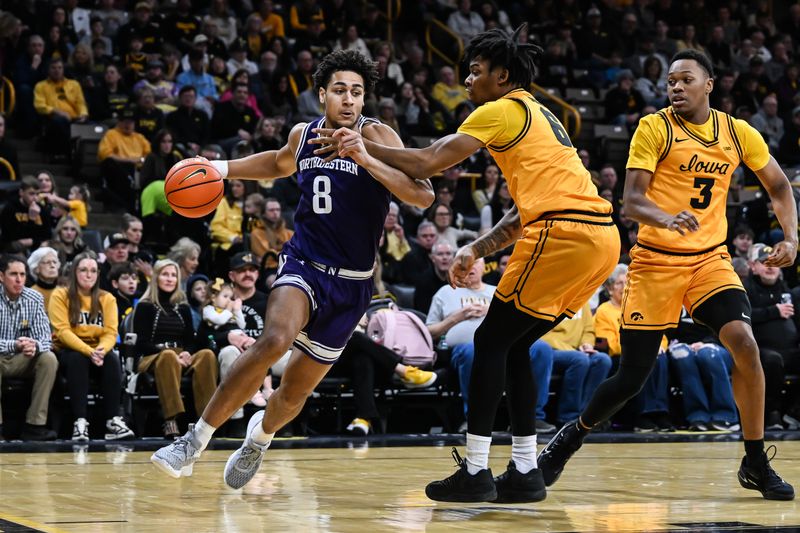 Feb 8, 2026; Iowa City, Iowa, USA; Northwestern Wildcats forward Tre Singleton (8) goes to the basket while being defended by Iowa Hawkeyes guard Tavion Banks (6) and forward Cam Manyawu (3) during the first half at Carver-Hawkeye Arena. Mandatory Credit: Jeffrey Becker-Imagn Images