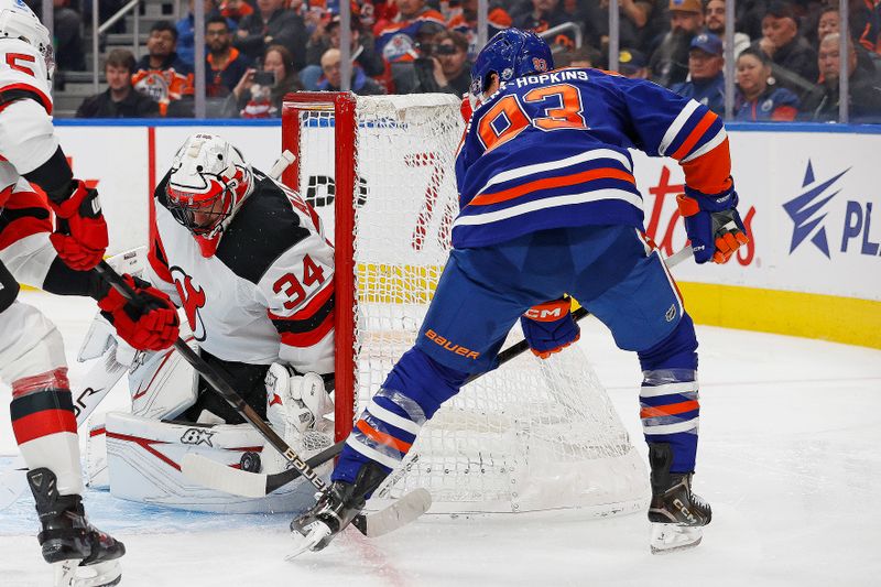 Nov 4, 2024; Edmonton, Alberta, CAN; New Jersey Devils goaltender Jake Allen (34) makes a save on Edmonton Oilers forward Ryan Nugent-Hopkins (93) during the third period at Rogers Place. Mandatory Credit: Perry Nelson-Imagn Images