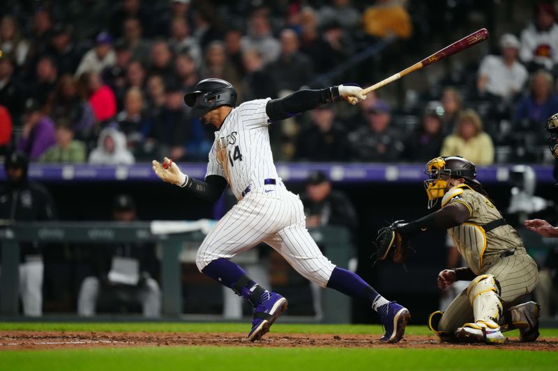 Apr 23, 2024; Denver, Colorado, USA; Colorado Rockies shortstop Ezequiel Tovar (14) hits an RBI single in the fifth inning against the San Diego Padres at Coors Field. Mandatory Credit: Ron Chenoy-USA TODAY Sports