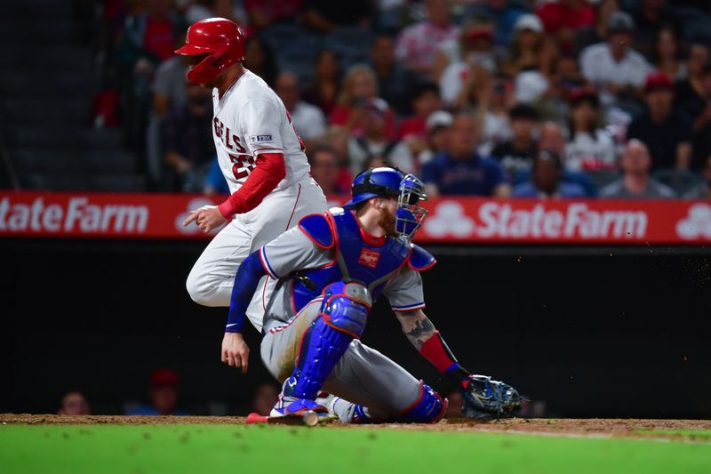 Sep 26, 2023; Anaheim, California, USA; Los Angeles Angels first baseman Brandon Drury (23) scores a run past Texas Rangers catcher Jonah Heim (28) during the fifth inning  at Angel Stadium. Mandatory Credit: Gary A. Vasquez-USA TODAY Sports