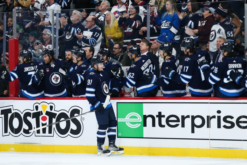 Nov 30, 2023; Winnipeg, Manitoba, CAN; Winnipeg Jets forward Cole Perfetti (91) is congratulated by his team mates on his goal against the Edmonton Oilers during the first period at Canada Life Centre. Mandatory Credit: Terrence Lee-USA TODAY Sports