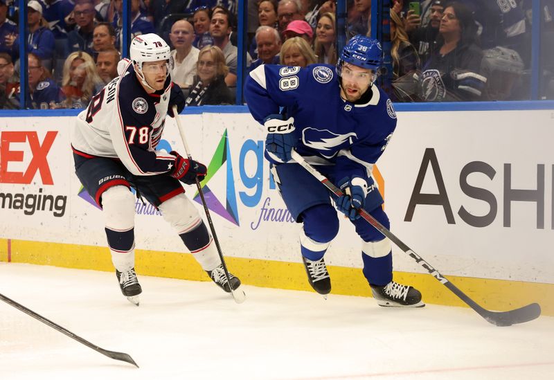 Apr 9, 2024; Tampa, Florida, USA; Tampa Bay Lightning left wing Brandon Hagel (38) skates with the puck as Columbus Blue Jackets defenseman Damon Severson (78) defends during the first period at Amalie Arena. Mandatory Credit: Kim Klement Neitzel-USA TODAY Sports