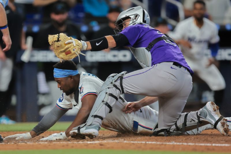 Jun 4, 2025; Miami, Florida, USA; Miami Marlins right fielder Jesus Sanchez (7) is tagged out at home plate by Colorado Rockies catcher Jacob Stallings (25) during the seventh inning at loanDepot Park. Mandatory Credit: Sam Navarro-Imagn Images