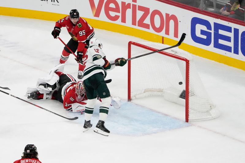 Nov 26, 2025; Chicago, Illinois, USA; Minnesota Wild left wing Matt Boldy (12) scores a goal on Chicago Blackhawks goaltender Spencer Knight (30) during the third period at United Center. Mandatory Credit: David Banks-Imagn Images