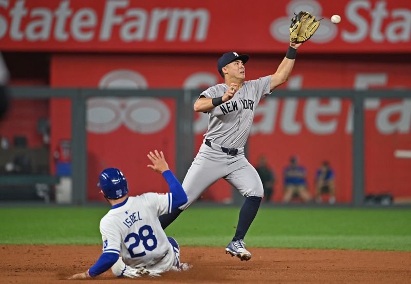 Jun 11, 2024; Kansas City, Missouri, USA; New York Yankees shortstop Anthony Volpe (11) forces out Kansas City Royals base runner Kyle Isbel (28) at second base in the ninth inning at Kauffman Stadium. Mandatory Credit: Peter Aiken-USA TODAY Sports