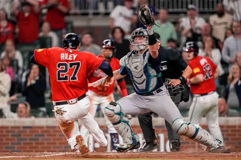 May 19, 2023; Cumberland, Georgia, USA; Seattle Mariners catcher Cal Raleigh (29) tries to tag out Atlanta Braves third baseman Austin Riley (27) during the eighth inning at Truist Park. Mandatory Credit: Dale Zanine-USA TODAY Sports