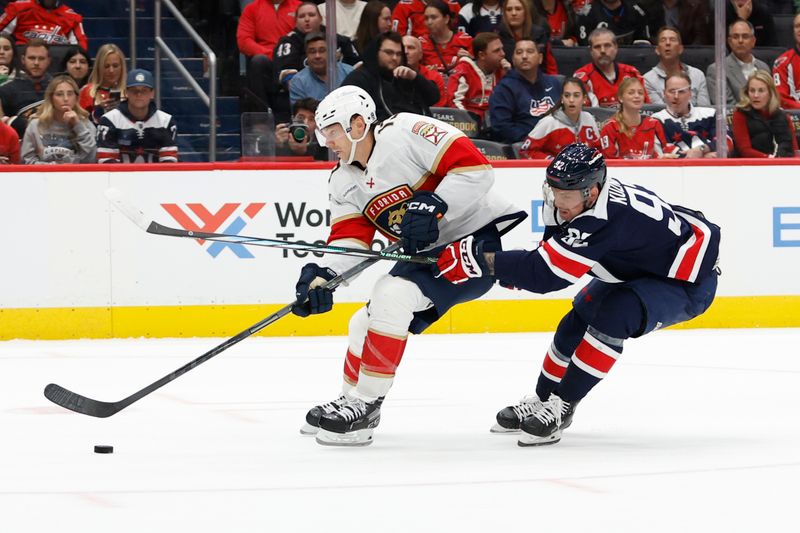 Nov 8, 2023; Washington, District of Columbia, USA; Florida Panthers center Sam Reinhart (13) skates with the puck as Washington Capitals center Evgeny Kuznetsov (92) defends in overtime at Capital One Arena. Mandatory Credit: Geoff Burke-USA TODAY Sports