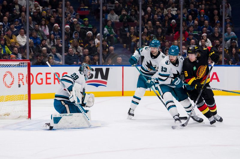 iDec 23, 2023; Vancouver, British Columbia, CAN; San Jose Sharks defenseman Marc-Edouard Vlasic (44) and defenseman Nikita Okhotiuk (83) and Vancouver Canucks forward Brock Boeser (6) watch the shot from forward Andrei Kuzmenko (96) beat goalie Mackenzie Blackwood (29) in the first period at Rogers Arena. Mandatory Credit: Bob Frid-USA TODAY Sports