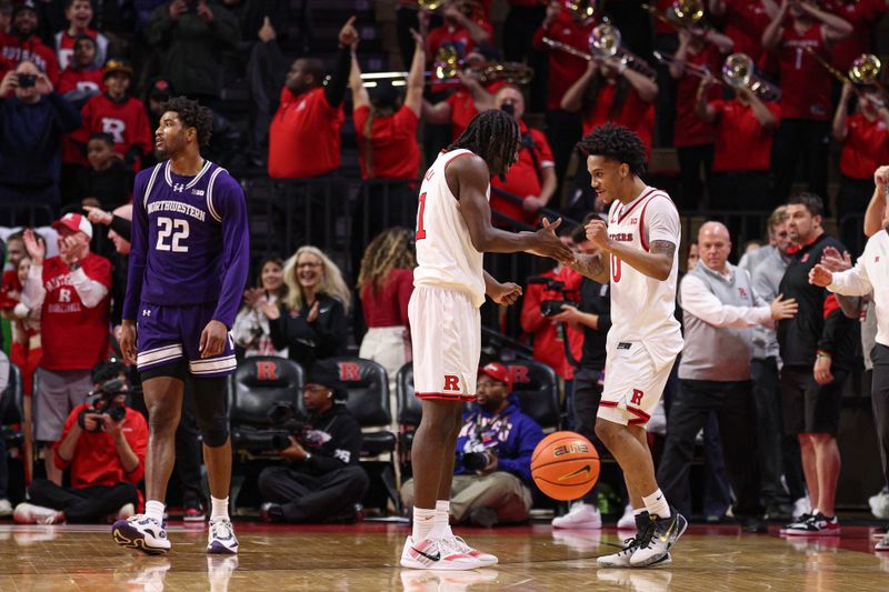 Jan 11, 2026; Piscataway, New Jersey, USA; Rutgers Scarlet Knights forward Christopher Nwuli (11)and guard Tariq Francis (0) celebrate after defeating Northwestern Wildcats in overtime at Jersey Mike's Arena. Mandatory Credit: Vincent Carchietta-Imagn Images