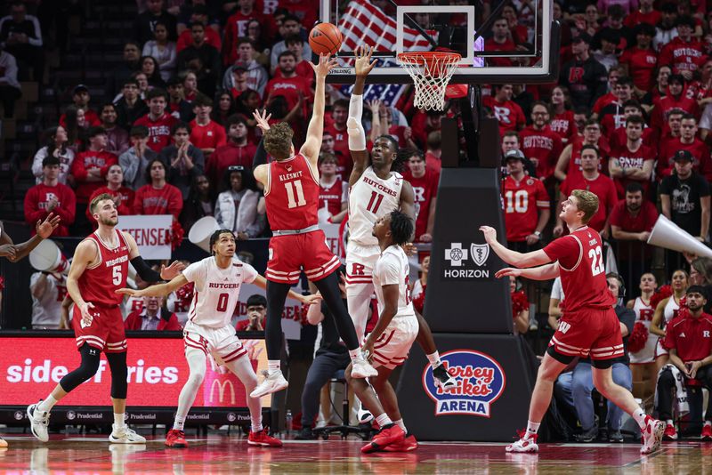 Feb 10, 2024; Piscataway, New Jersey, USA; Wisconsin Badgers guard Max Klesmit (11) shoots the ball against Rutgers Scarlet Knights center Clifford Omoruyi (11) during the second half at Jersey Mike's Arena. Mandatory Credit: Vincent Carchietta-USA TODAY Sports