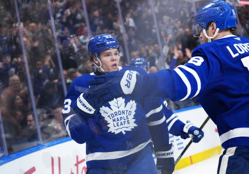 Dec 13, 2025; Toronto, Ontario, CAN; Toronto Maple Leafs right wing Easton Cowan (53) scores a goal and celebrates with center Steven Lorentz (18) against the Edmonton Oilers during the first period at Scotiabank Arena. Mandatory Credit: Nick Turchiaro-Imagn Images