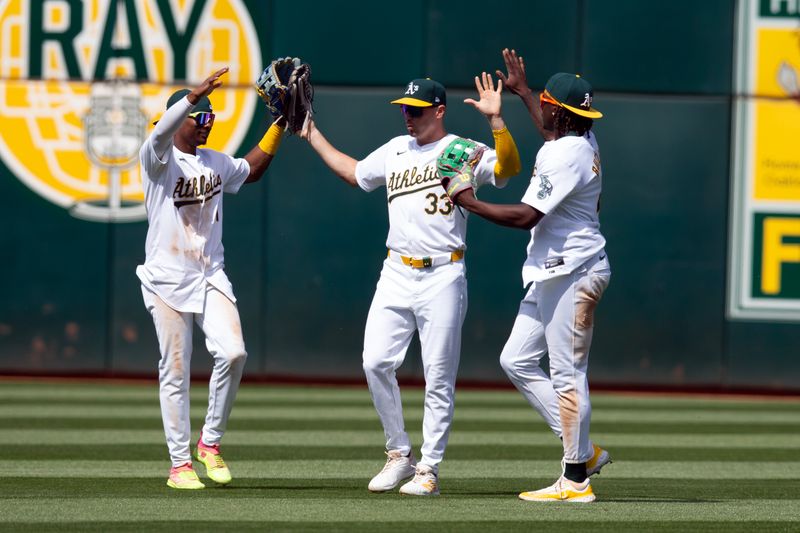 Apr 17, 2024; Oakland, California, USA; Oakland Athletics outfielders Esteury Ruiz (1), JJ Bleday (33) and Lawrence Butler (4) celebrate their 6-3 victory over the St. Louis Cardinals at Oakland-Alameda County Coliseum. Mandatory Credit: D. Ross Cameron-USA TODAY Sports