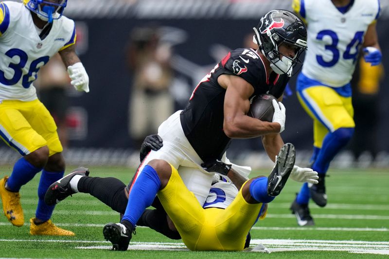 Houston Texans wide receiver Xavier Hutchinson (19) is tackled by Los Angeles Rams cornerback Tre Tomlinson (6) after catching a pass during the first half of a preseason NFL football game, Saturday, Aug. 24, 2024, in Houston. (AP Photo/Eric Gay)