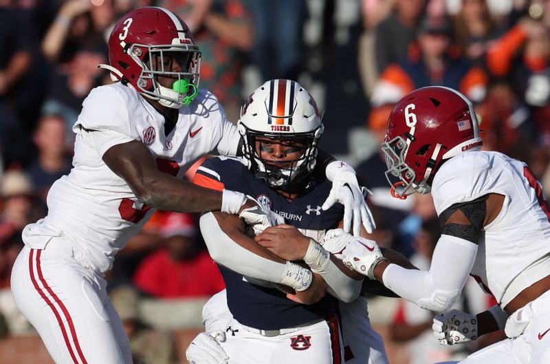 Nov 25, 2023; Auburn, Alabama, USA;  Auburn Tigers running back Jarquez Hunter (27) is tackled by Alabama Crimson Tide defensive back Terrion Arnold (3) and defensive back Jaylen Key (6) during the first quarter at Jordan-Hare Stadium. Mandatory Credit: John Reed-USA TODAY Sports