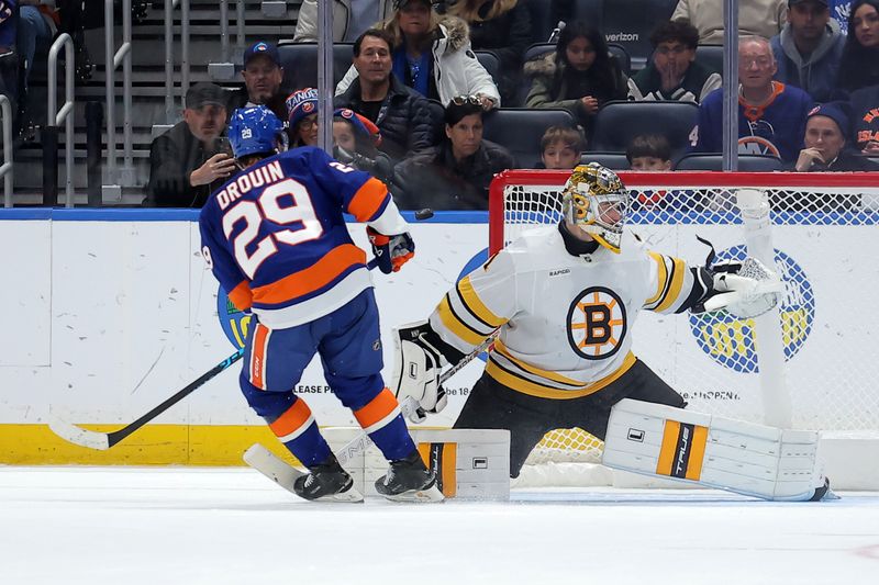 Nov 4, 2025; Elmont, New York, USA; Boston Bruins goaltender Jeremy Swayman (1) makes a save against New York Islanders left wing Jonathan Drouin (29) during the shootout at UBS Arena. Mandatory Credit: Brad Penner-Imagn Images