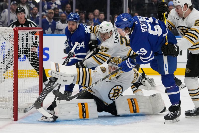 Apr 24, 2024; Toronto, Ontario, CAN; Boston Bruins goaltender Jeremy Swayman (1) makes a save on Toronto Maple Leafs forward Tyler Bertuzzi (59) as Boston Bruins defenseman Brandon Carlo (25) helps defend during the third period of game three of the first round of the 2024 Stanley Cup Playoffs at Scotiabank Arena. Mandatory Credit: John E. Sokolowski-USA TODAY Sports