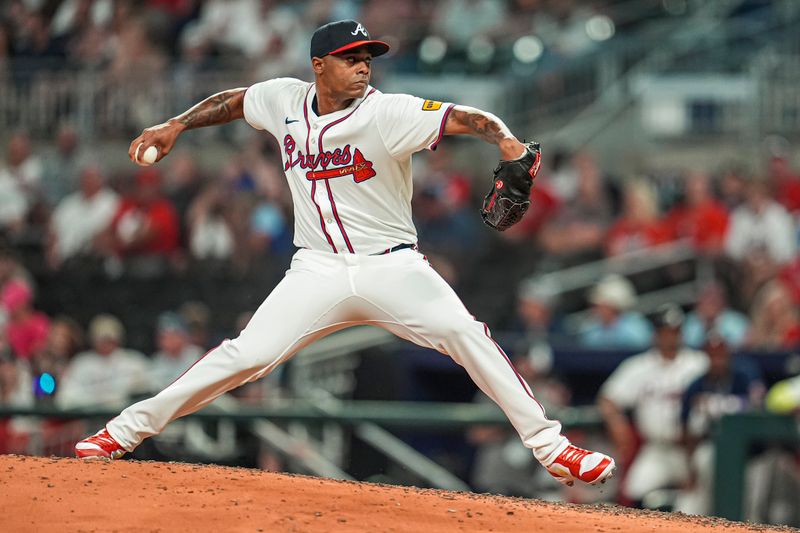 Aug 20, 2024; Cumberland, Georgia, USA; Atlanta Braves relief pitcher Raisel Iglesias (26)  pitches against the Philadelphia Phillies during the ninth inning at Truist Park. Mandatory Credit: Dale Zanine-USA TODAY Sports