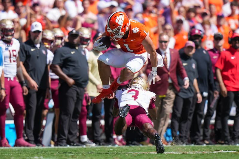 Sep 23, 2023; Clemson, South Carolina, USA; Clemson Tigers running back Will Shipley (1) jumps over Florida State Seminoles defensive back Kevin Knowles II (3) in the first quarter at Memorial Stadium. Mandatory Credit: David Yeazell-USA TODAY Sports