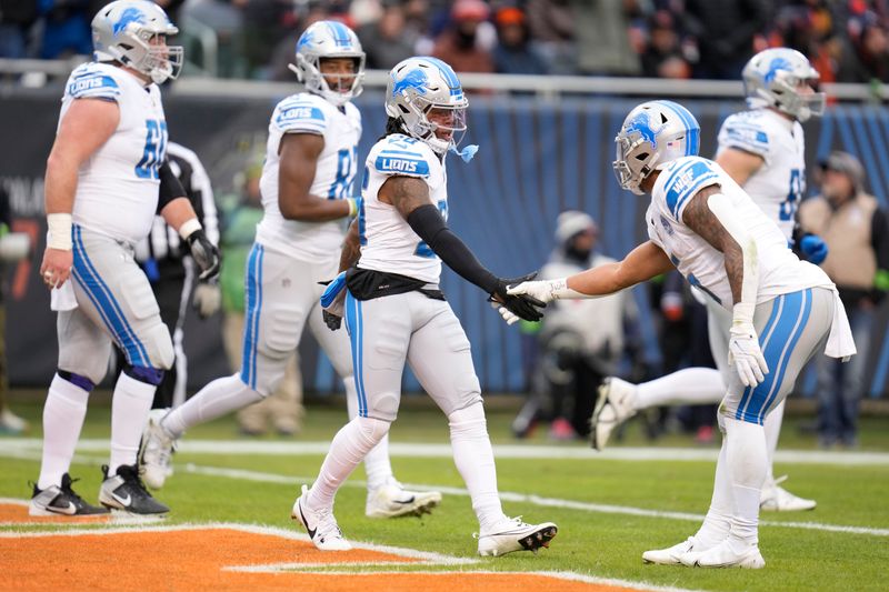 Detroit Lions running back Jahmyr Gibbs, center, celebrates his rushing touchdown with running back David Montgomery during the first half of an NFL football game against the Chicago Bears Sunday, Dec. 10, 2023, in Chicago. (AP Photo/Erin Hooley)