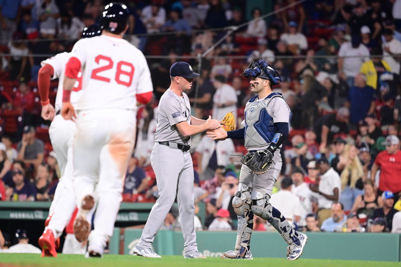 Jul 28, 2024; Boston, Massachusetts, USA; New York Yankees pitcher Caleb Ferguson (64) and catcher Austin Wells (28) celebrate defeating the Boston Red Sox at Fenway Park. Mandatory Credit: Eric Canha-USA TODAY Sports