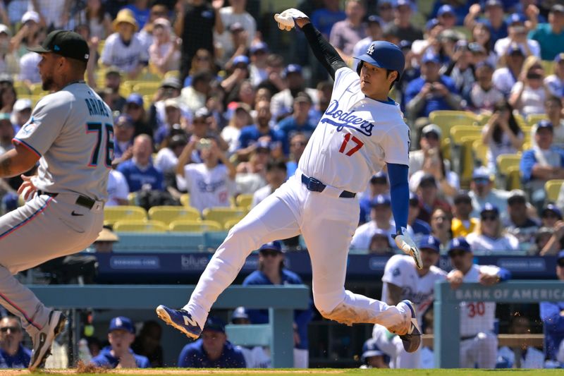 Apr 30, 2025; Los Angeles, California, USA;  Los Angeles Dodgers designated hitter Shohei Ohtani (17) beats the tag by Miami Marlins relief pitcher Luarbert Arias (76) scoring on a wild pitch in the eighth inning at Dodger Stadium. Mandatory Credit: Jayne Kamin-Oncea-Imagn Images