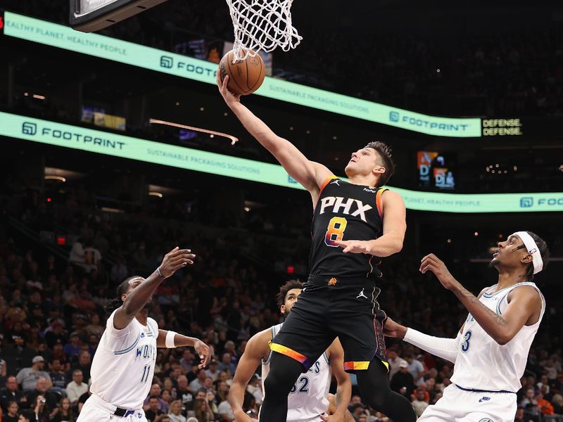 PHOENIX, ARIZONA - NOVEMBER 15: Grayson Allen #8 of the Phoenix Suns lays up a shot past Jaden McDaniels #3 of the Minnesota Timberwolves during the second half of the NBA game at Footprint Center on November 15, 2023 in Phoenix, Arizona. The Suns defeated the Timberwolves 133-115. NOTE TO USER: User expressly acknowledges and agrees that, by downloading and or using this photograph, User is consenting to the terms and conditions of the Getty Images License Agreement.  (Photo by Christian Petersen/Getty Images)