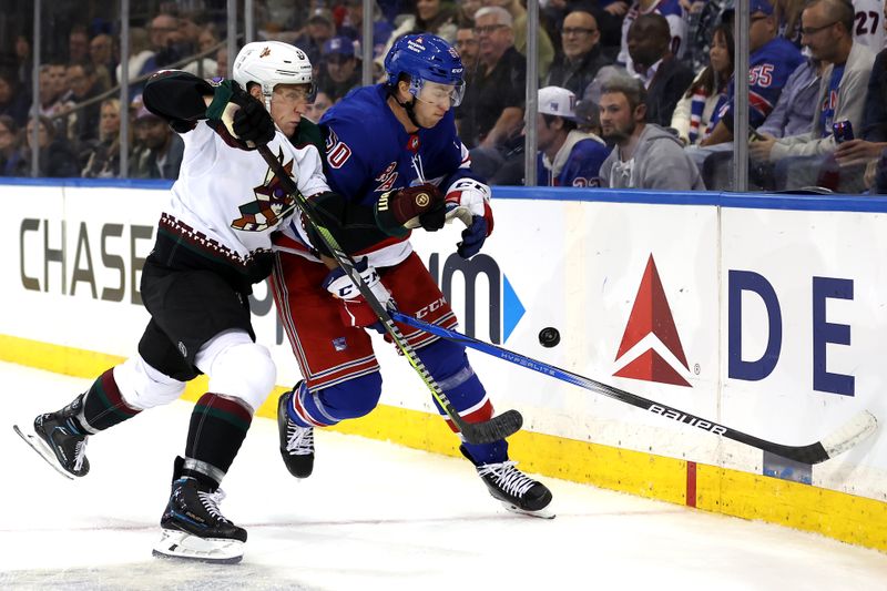 Oct 16, 2023; New York, New York, USA; Arizona Coyotes defenseman Travis Dermott (33) and New York Rangers left wing Will Cuylle (50) fight for the puck during the second period at Madison Square Garden. Mandatory Credit: Brad Penner-USA TODAY Sports