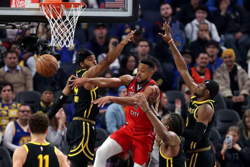 SAN FRANCISCO, CALIFORNIA - JANUARY 10: CJ McCollum #3 of the New Orleans Pelicans passes the ball around Moses Moody #4, Jonathan Kuminga #00 and Kevon Looney #5 of the Golden State Warriors at Chase Center on January 10, 2024 in San Francisco, California. NOTE TO USER: User expressly acknowledges and agrees that, by downloading and or using this photograph, User is consenting to the terms and conditions of the Getty Images License Agreement.  (Photo by Ezra Shaw/Getty Images)