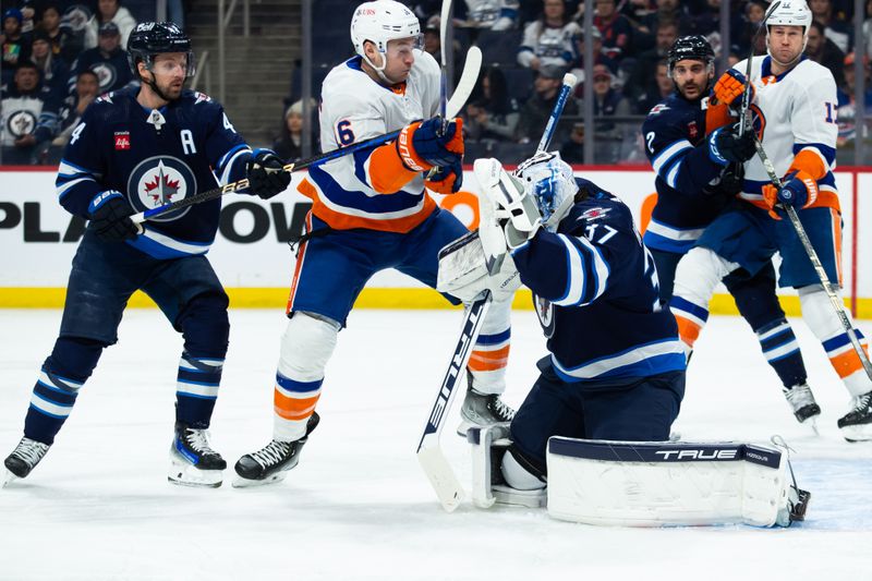 Jan 16, 2024; Winnipeg, Manitoba, CAN; New York Islanders forward Julien Gauthier (16) jostles for position with Winnipeg Jets defenseman Josh Morrissey (44) during the first period at Canada Life Centre. Mandatory Credit: Terrence Lee-USA TODAY Sports