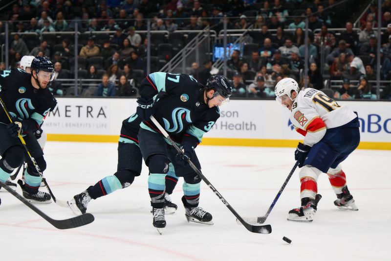 Dec 12, 2023; Seattle, Washington, USA; Seattle Kraken center Yanni Gourde (37) clears the puck away from Florida Panthers left wing Matthew Tkachuk (19) during the third period at Climate Pledge Arena. Mandatory Credit: Steven Bisig-USA TODAY Sports