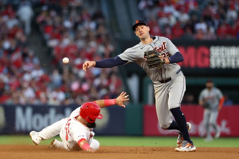Jun 28, 2024; Anaheim, California, USA;  Detroit Tigers shortstop Ryan Kreidler (32) throws to first as Los Angeles Angels second baseman Luis Guillorme (15) is out at second on a double play during the fifth inning at Angel Stadium. Mandatory Credit: Kiyoshi Mio-USA TODAY Sports