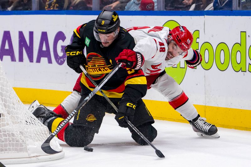 Oct 28, 2024; Vancouver, British Columbia, CAN; Vancouver Canucks forward J.T. Miller (9) battles with Carolina Hurricanes forward Jordan Martinook (48) during the first period at Rogers Arena. Mandatory Credit: Bob Frid-Imagn Images