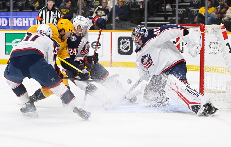 Jan 17, 2023; Nashville, Tennessee, USA;  Columbus Blue Jackets goaltender Daniil Tarasov (40) blocks the shot of Nashville Predators center Juuso Parssinen (75) during the first period at Bridgestone Arena. Mandatory Credit: Steve Roberts-USA TODAY Sports