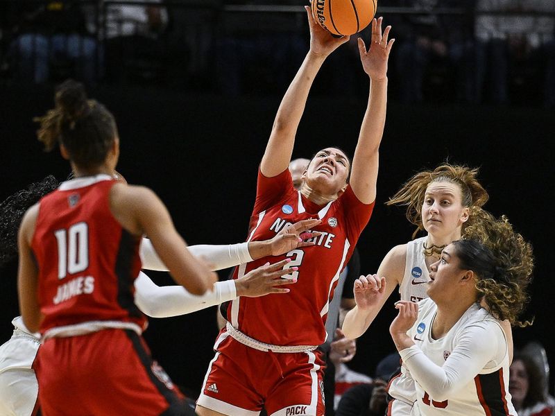 Mar 29, 2024; Portland, OR, USA; NC State Wolfpack forward Mimi Collins (2) is triple teamed as she catches the ball during the second half against Stanford Cardinal guard Talana Lepolo (10) in the semifinals of the Portland Regional of the 2024 NCAA Tournament at the Moda Center at the Moda Center. Mandatory Credit: Troy Wayrynen-USA TODAY Sports