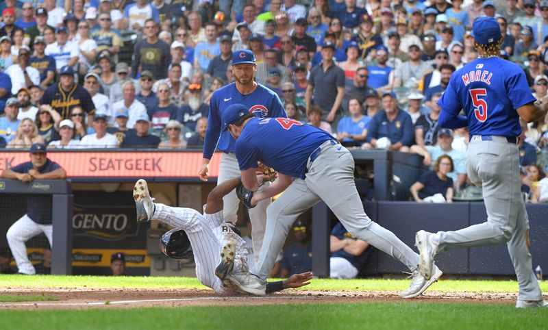 Jun 29, 2024; Milwaukee, Wisconsin, USA; Milwaukee Brewers second baseman Andruw Monasterio (14) is tagged out by Chicago Cubs relief pitcher Tyson Miller (49) after a rundown in the seventh inning at American Family Field. Mandatory Credit: Michael McLoone-USA TODAY Sports