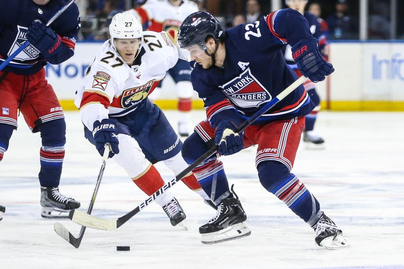 Mar 23, 2024; New York, New York, USA; Florida Panthers center Eetu Luostarinen (27) and New York Rangers defenseman Adam Fox (23) battle for control of the puck in the third period at Madison Square Garden. Mandatory Credit: Wendell Cruz-USA TODAY Sports