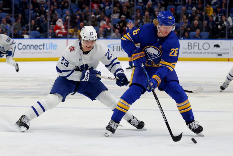 Dec 21, 2023; Buffalo, New York, USA;  Buffalo Sabres defenseman Rasmus Dahlin (26) controls the puck as Toronto Maple Leafs left wing Matthew Knies (23) defends during the third period at KeyBank Center. Mandatory Credit: Timothy T. Ludwig-USA TODAY Sports