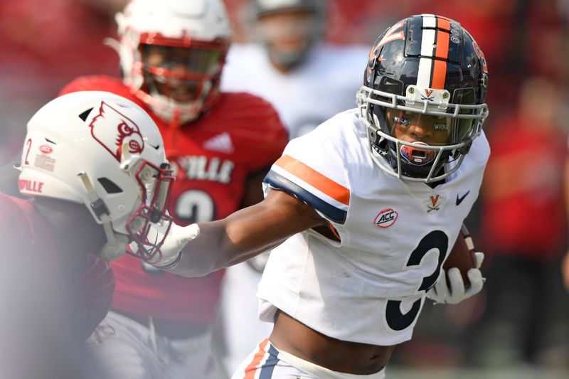 Oct 9, 2021; Louisville, Kentucky, USA;  Virginia Cavaliers wide receiver Dontayvion Wicks (3) runs the ball against Louisville Cardinals defensive back Chandler Jones (2)  during the first quarter at Cardinal Stadium. Mandatory Credit: Jamie Rhodes-USA TODAY Sports
