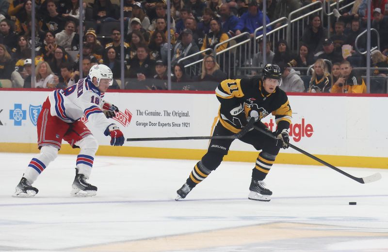 Oct 11, 2025; Pittsburgh, Pennsylvania, USA;  Pittsburgh Penguins center Filip Hallander (11) moves the puck against New York Rangers defenseman Urho Vaakanainen (18) during the second period at PPG Paints Arena. Mandatory Credit: Charles LeClaire-Imagn Images