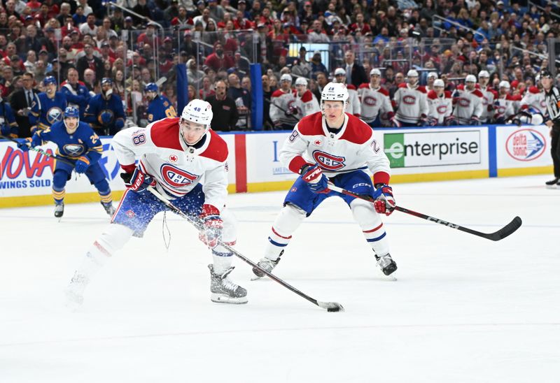 Nov 11, 2024; Buffalo, New York, USA; Montreal Canadiens defenseman Lane Hutson (48) shoots the puck against the Buffalo Sabres with center Christian Dvorak (28) behind in the third period at KeyBank Center. Mandatory Credit: Mark Konezny-Imagn Images