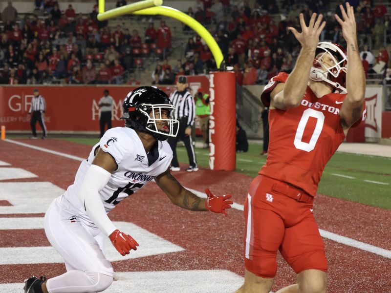 Nov 11, 2023; Houston, Texas, USA; Houston Cougars wide receiver Joseph Manjack IV (0) catches a pass for a touchdown against Cincinnati Bearcats defensive back Taj Ward (15) in the first half at TDECU Stadium. Mandatory Credit: Thomas Shea-USA TODAY Sports