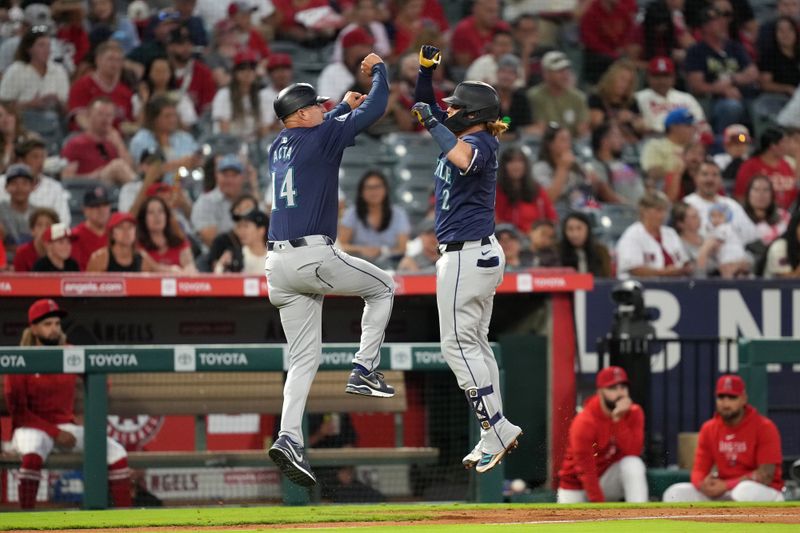 Aug 31, 2024; Anaheim, California, USA; Seattle Mariners first baseman Justin Turner (2) celebrates with third base coach Manny Acta (14) after hitting a home run in the fourth inning against the Los Angeles Angels at Angel Stadium. Mandatory Credit: Kirby Lee-USA TODAY Sports