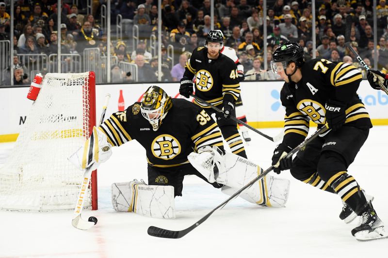 Apr 16, 2024; Boston, Massachusetts, USA;  Boston Bruins goaltender Linus Ullmark (35) gathers the puck while defenseman Charlie McAvoy (73) looks on during the second period against the Ottawa Senators at TD Garden. Mandatory Credit: Bob DeChiara-USA TODAY Sports