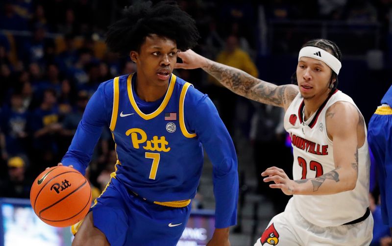 Feb 17, 2024; Pittsburgh, Pennsylvania, USA;  Pittsburgh Panthers guard Carlton Carrington (7) drives to the basket against Louisville Cardinals guard Tre White (22) during the first half at the Petersen Events Center. Mandatory Credit: Charles LeClaire-USA TODAY Sports